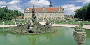 Blick vom Herkulesbrunnen im Schlossgarten zum Schloss Weikersheim