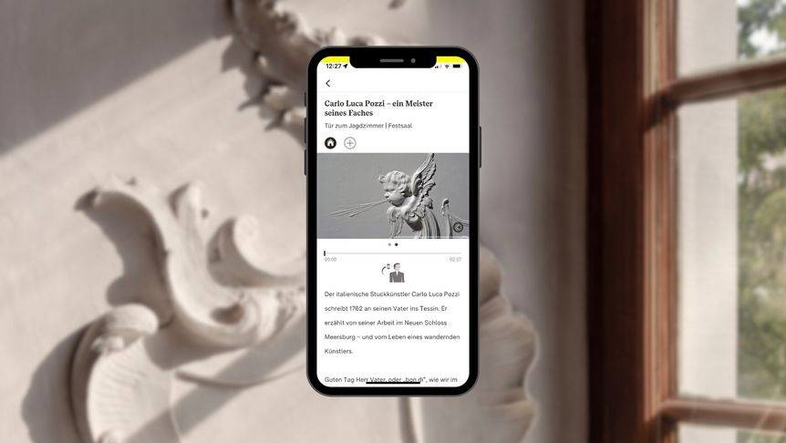 Smartphone mit Vielfalt-Tourstation vor einem Stuckdetail im Neuen Schloss Meersburg