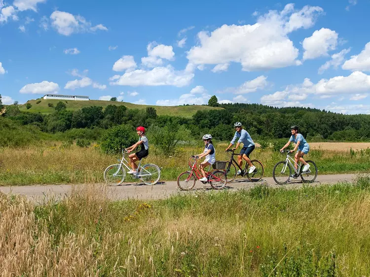 Foto: Staatliche Schlösser und Gärten Baden-Württemberg, Niels Schubert Radelnde Familie mit Heuneburg im Hintergrund