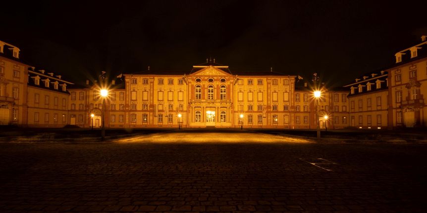 Blick auf das beleuchtete Schloss Bruchsal bei Nacht