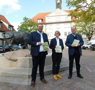 Kloster Ochsenhausen, Foto von drei Personen, die im Klosterhof stehen und die Broschüre in den Händen halten